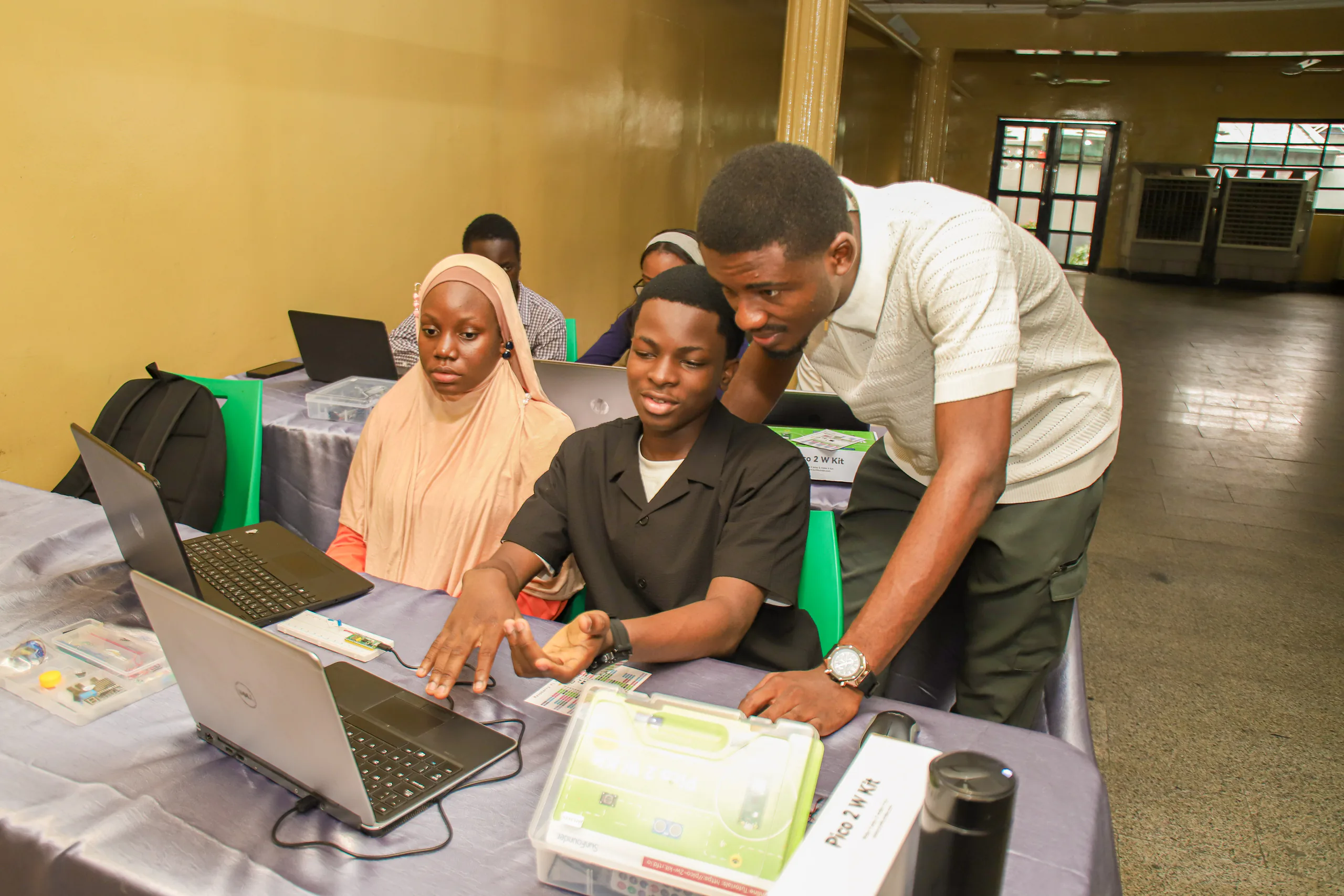 PEAR students and mentor working together at a laptop.